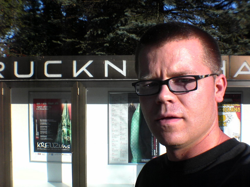 garnet hertz in front of brucknerhaus sign in linz austria.